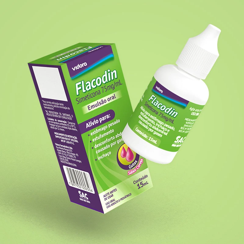 Green and purple package of simeticone oral emulsion ('Flacodin') next to its white dropper bottle, set on a light green background.